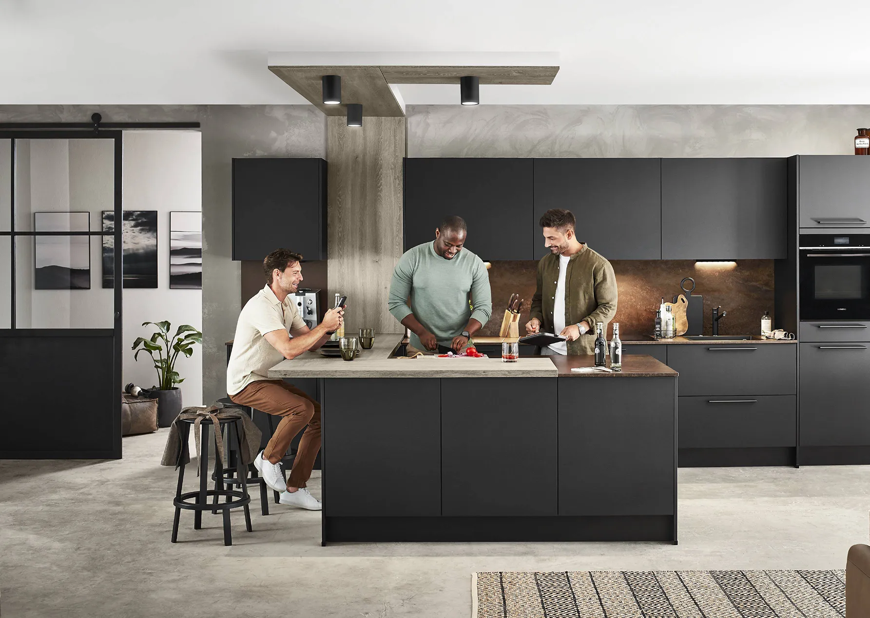 Modern matte kitchen with black cabinetry, a bronze backsplash, and a central island, styled with industrial design elements and a relaxed social atmosphere. Modern matte kitchen with black cabinetry, a bronze backsplash, and a central island, styled with industrial design elements and a relaxed social atmosphere.