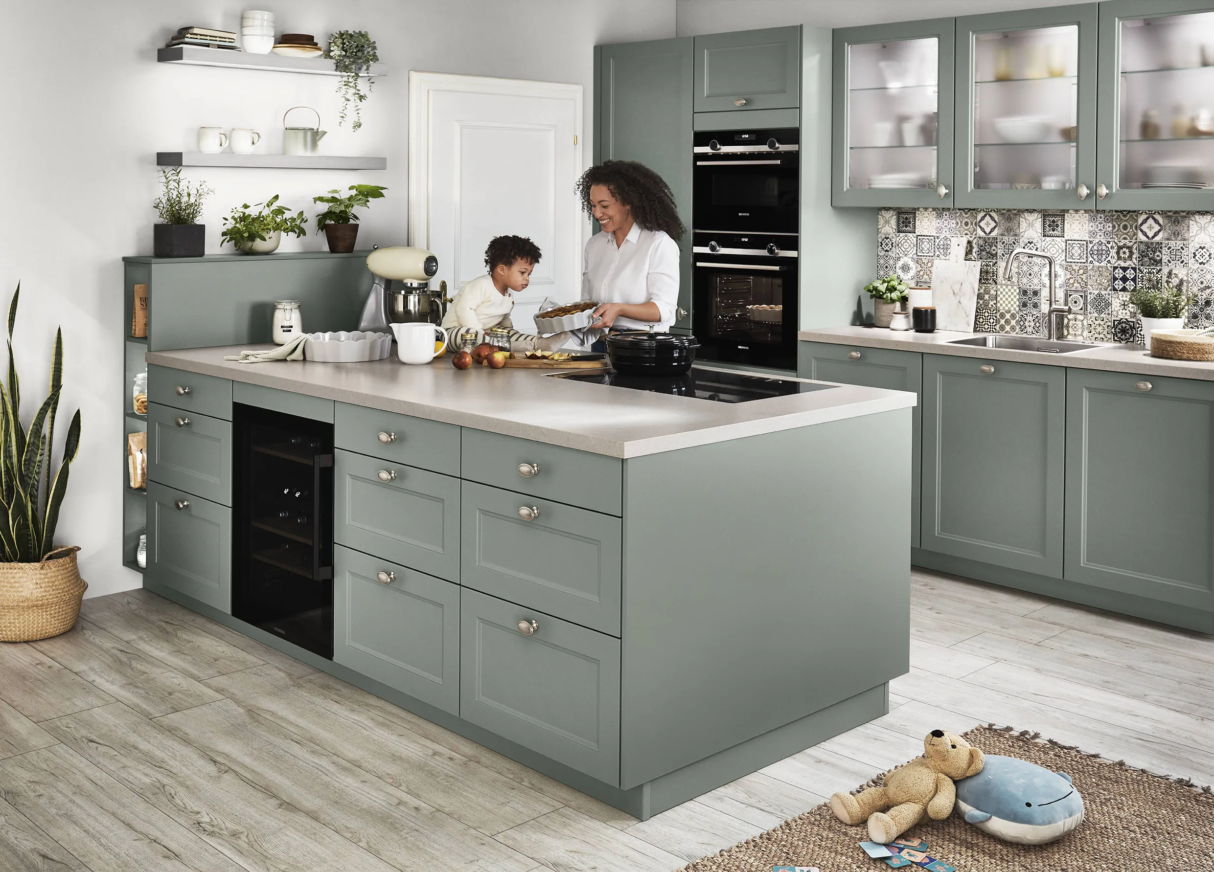 Mother and child baking in a pastel green kitchen with ample storage and a large island, showcasing smart storage solutions and family-friendly design. Mother and child baking in a pastel green kitchen with ample storage and a large island, showcasing smart storage solutions and family-friendly design.