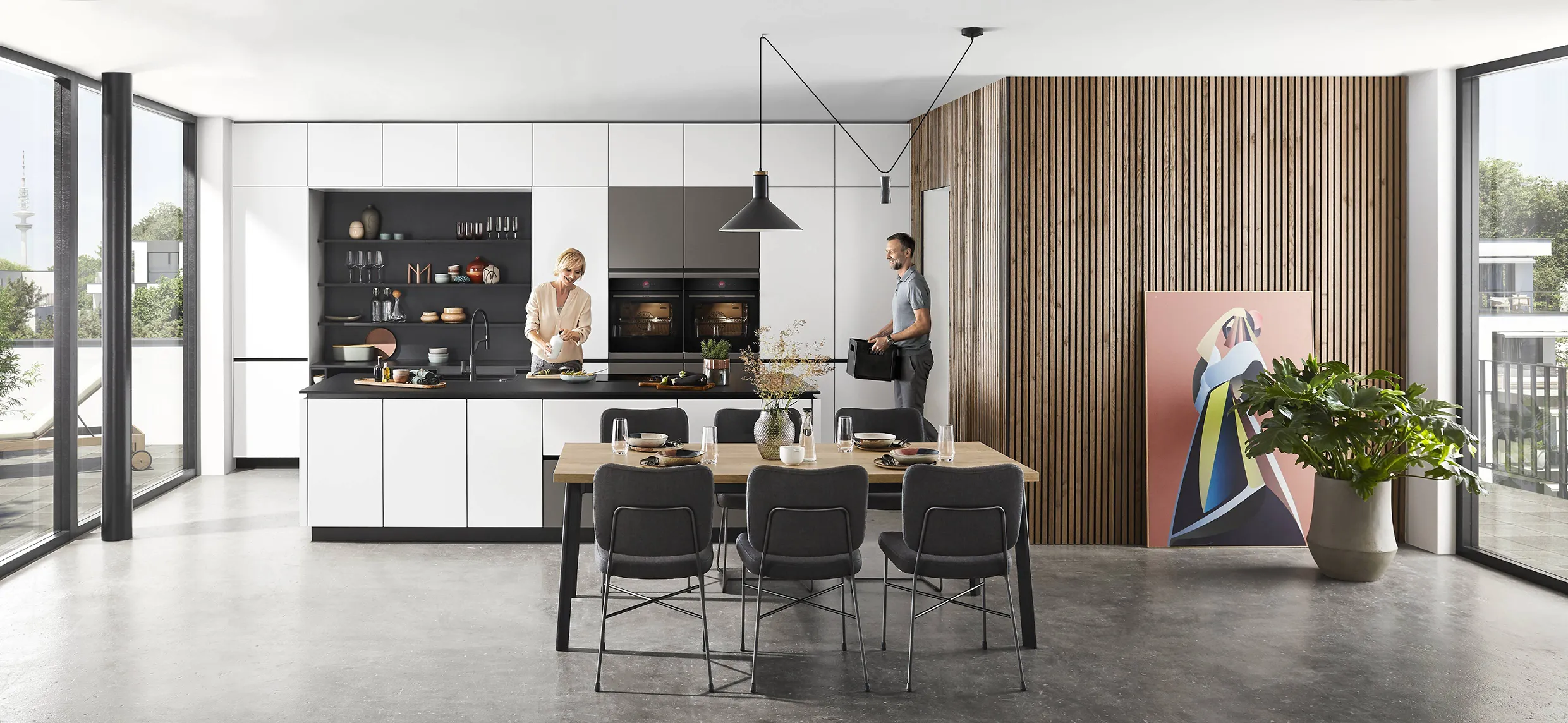 Spacious, modern kitchen with white and black cabinets, an open shelving unit, a dining area with wooden accents, and floor-to-ceiling windows providing ample natural light. Spacious, modern kitchen with white and black cabinets, an open shelving unit, a dining area with wooden accents, and floor-to-ceiling windows providing ample natural light.