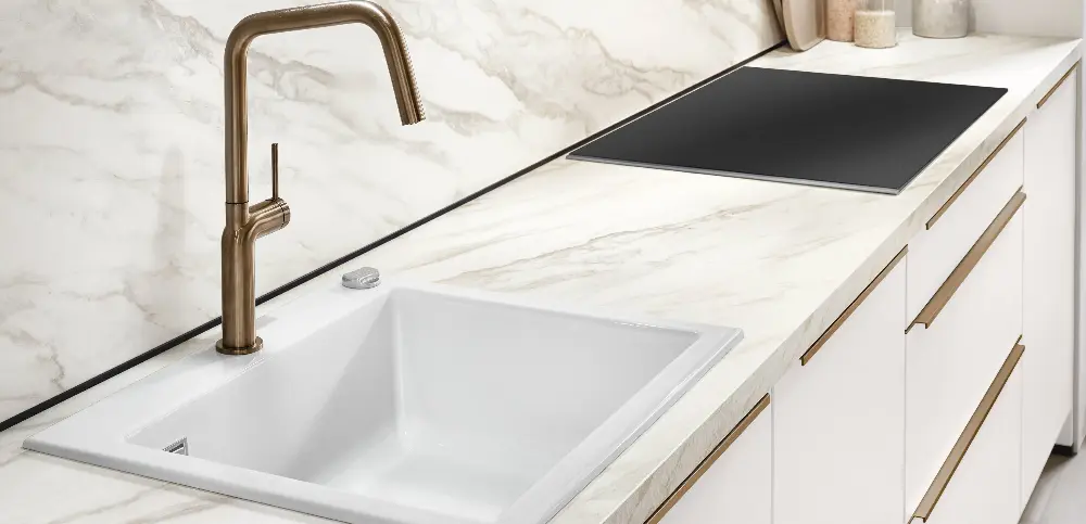 Clean white sink with a golden faucet Clean white sink with a golden faucet