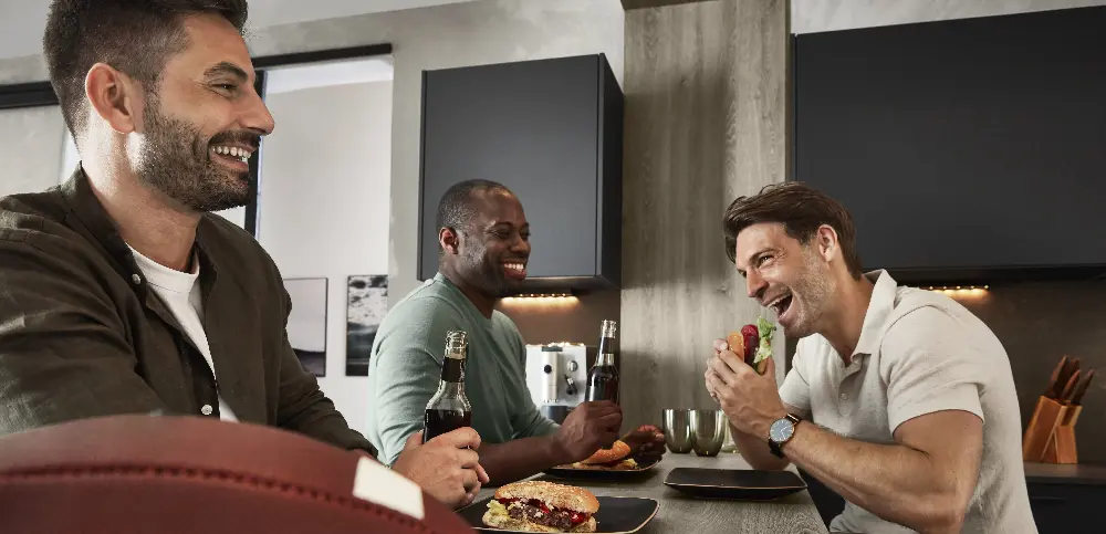 Three friends eating together while laughing and having fun Three friends eating together while laughing and having fun