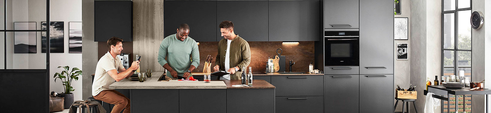 Three men preparing food in a black kitchen Three men preparing food in a black kitchen