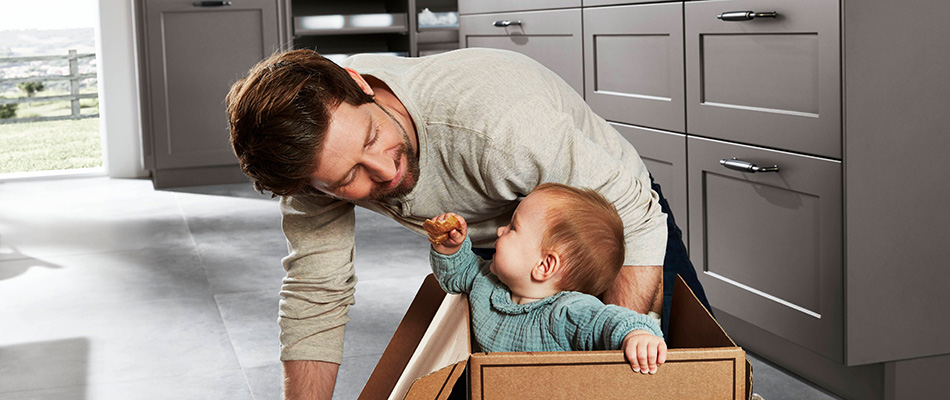 Father and baby son playing in kitchen Father and baby son playing in kitchen